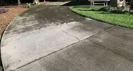Before photo of dirty concrete driveway before pressure washing in Winder Georgia